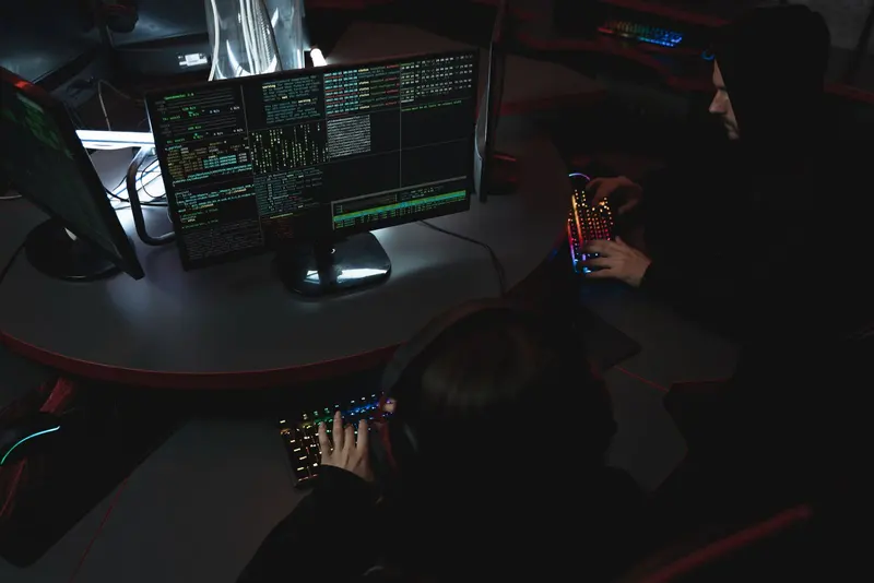 Analysts working at consoles in a darkened operations room
